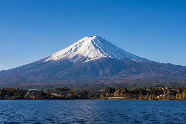 Mount Fuji's solitary snow-capped symmetrical cone rising above a lake