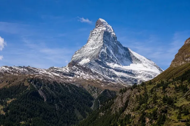 The Matterhorn's iconic crooked pyramid peak above the forested Zermatt valley